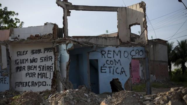 A message that reads in Portuguese; "evictions with ethics," right, covers a wall on the remains of a home in the Vila Autodromo slum, in Rio de Janeiro, Brazil, Wednesday, Jan. 27, 2016.  Most of the slum has been systematically bulldozed to make room for the construction of Olympic Park, the sport campus that will host the 2016 Summer Games. (AP Photo/Silvia Izquierdo)