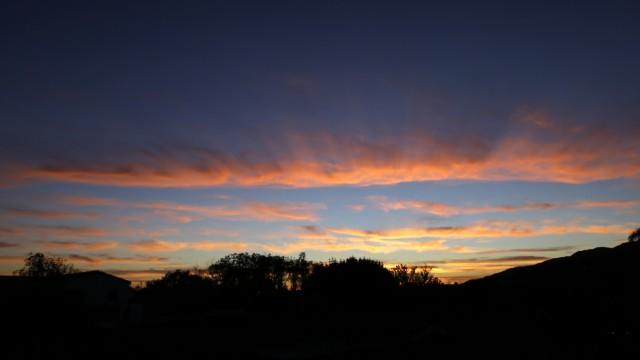 This Tuesday, Feb. 9, 2016 photo shows the sun setting over the Pacific Ocean, seen from the Pacific Palisades area of Los Angeles. A midwinter heat wave baked Southern California again Tuesday, breaking more February records as temperatures soared into the 80s and 90s even as the Santa Ana winds that stoked the atmosphere began to fade. The gusty, dry Santa Ana winds form as air descends through mountain passes and canyons, warming through compression and pushing out to sea. (AP Photo/Reed Saxon)