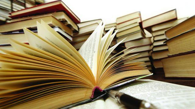 Many old books combined by a heap. Russian saying 'Knowledge - light, ignorance - darkness'