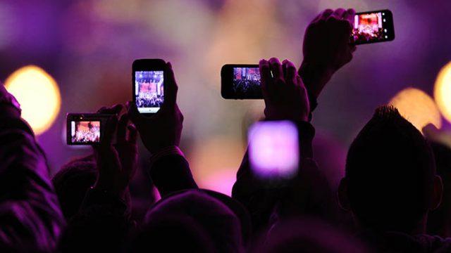 Fans take photos with their mobile phones during the VH1 "Divas Salute The Troops" show at the Marine Corps Air Station Miramar in San Diego, December 3, 2010. REUTERS/K.C. Alfred (UNITED STATES - Tags: ENTERTAINMENT SCI TECH IMAGES OF THE DAY) - RTXVDL9