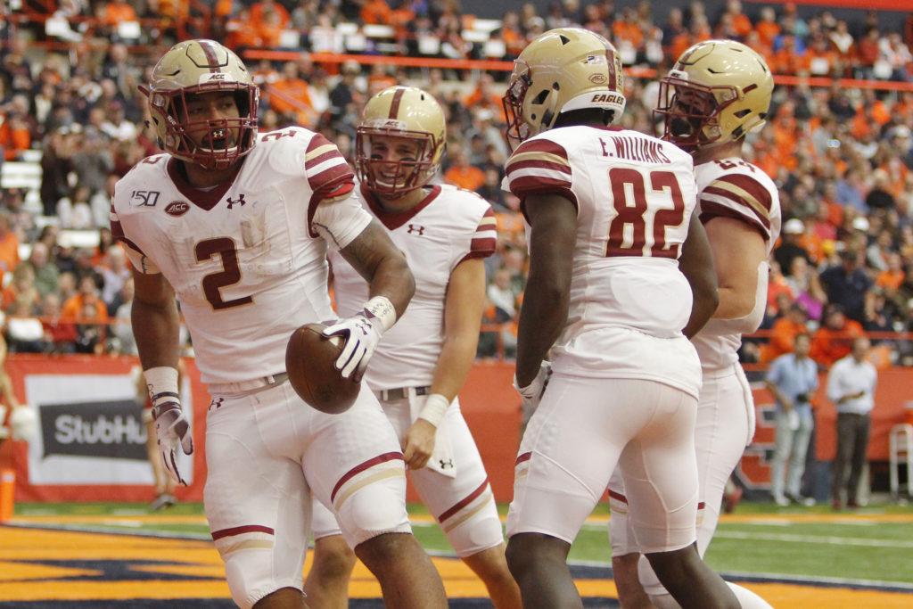 Boston College's AJ Dillon, left, celebrates with teammates after scoring a touchdown during the second quarter of an NCAA college football game against Boston College in Syracuse, N.Y., Saturday, Nov. 2, 2019. (AP Photo/Nick Lisi)