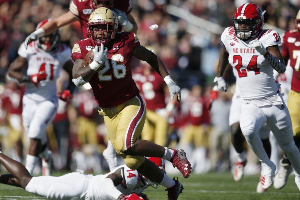 Boston College running back David Bailey (26) evades North Carolina State safety De'Von Graves (14) on a touchdown run during the first half of an NCAA college football game in Boston, Saturday, Oct. 19, 2019. (AP Photo/Michael Dwyer)