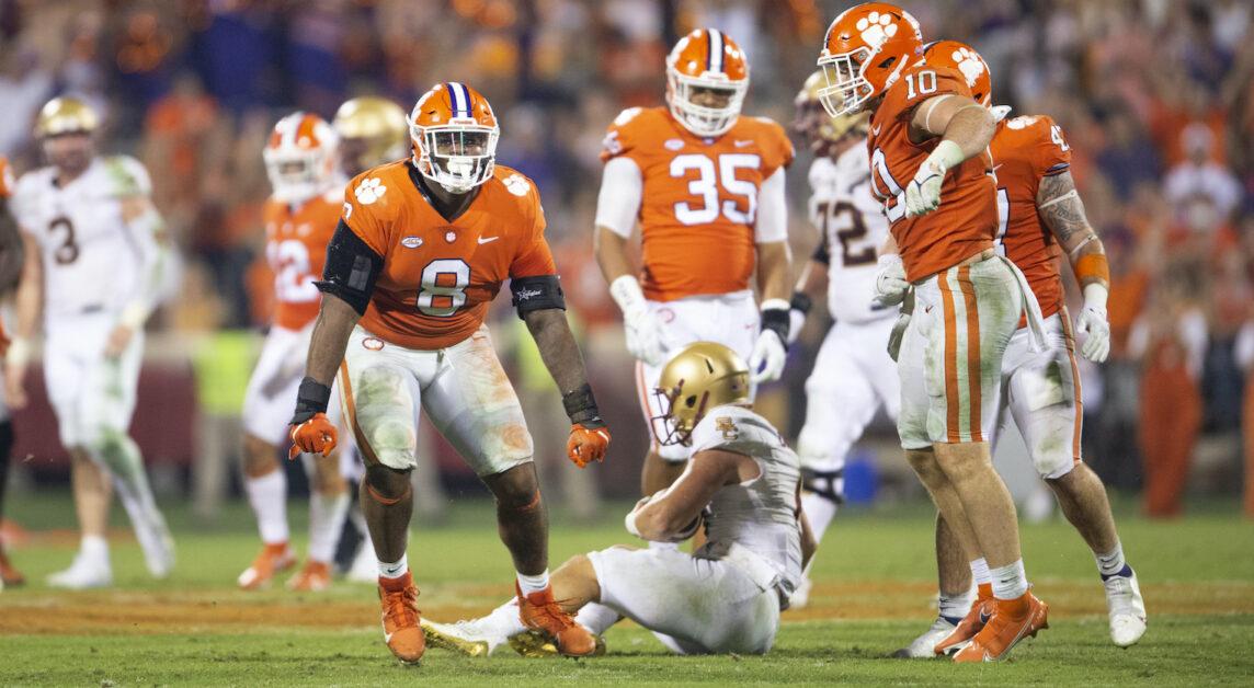 Clemson defensive tackle Tre Williams (8) and linebacker Baylon Spector (10) react after sacking Boston College quarterback Dennis Grosel, bottom center, during the second half of an NCAA college football game Saturday, Oct. 2, 2021, in Clemson, S.C. (AP Photo/Hakim Wright Sr.)