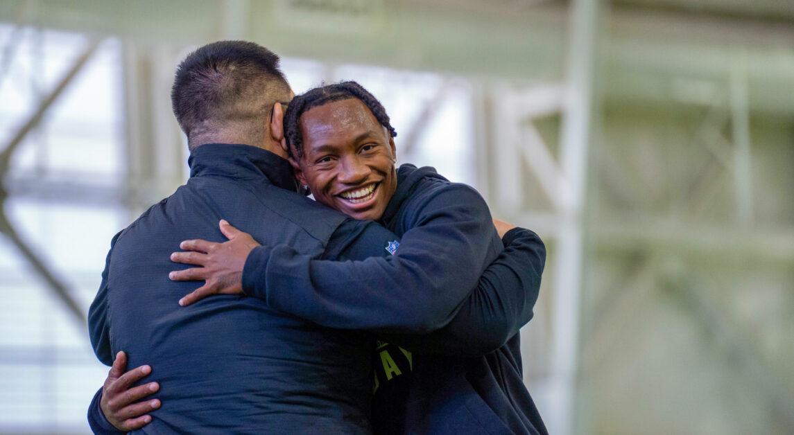 BC football player Zay Flowers hugs a football staff member at the BC Pro Day on Friday, March 26, 2023 (Kenneth Chen / Heights Staff).