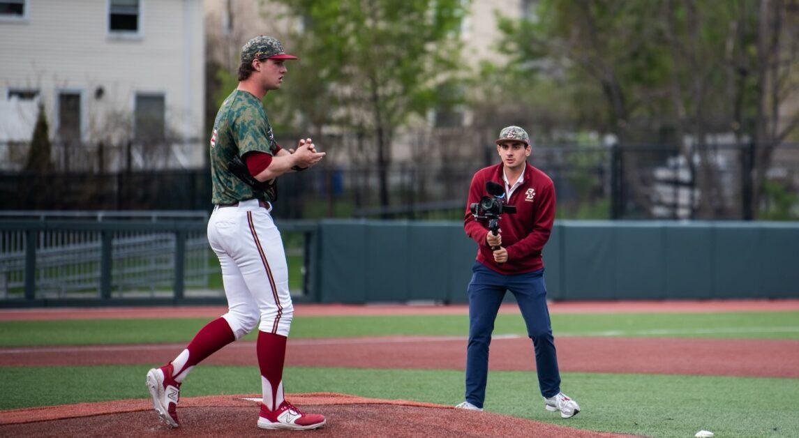 Matthew Ionescu (right), MCAS ‘25, films right-handed pitcher John West (left) taking the mound in Friday’s doubleheader against Clemson. (Photo Courtesy of Matthew Ionescu)