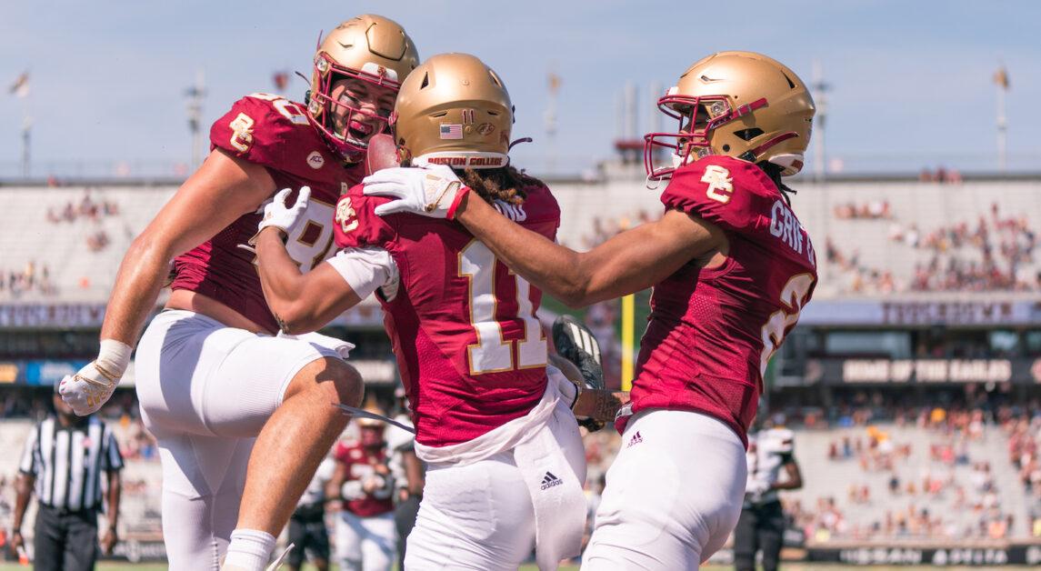 George Takacs and Joe Griffin embrace Lewis Bond in the endzone after a touchdown reception. (Chris Ticas / Heights Editor)