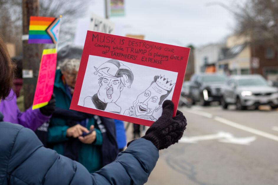 On Saturday afternoon, Newton residents protested in Newton Centre as part of nationwide “Hands Off” demonstrations.